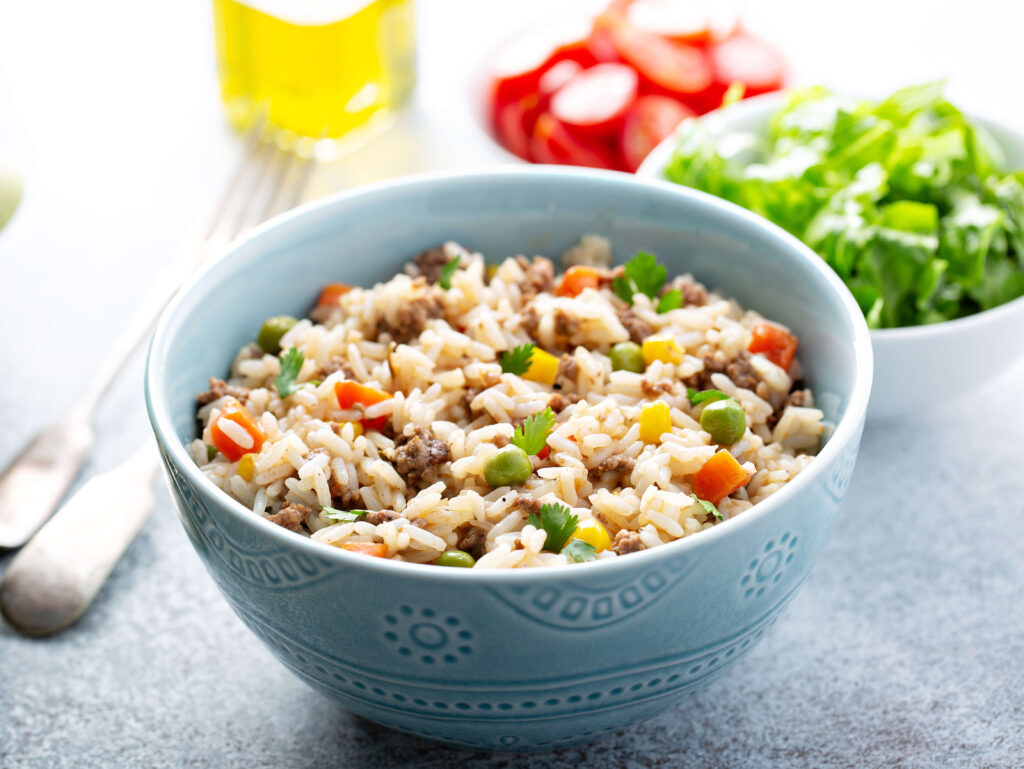 Tigela de arroz acompanhado de complementos, como vegetais, carne e temperos.