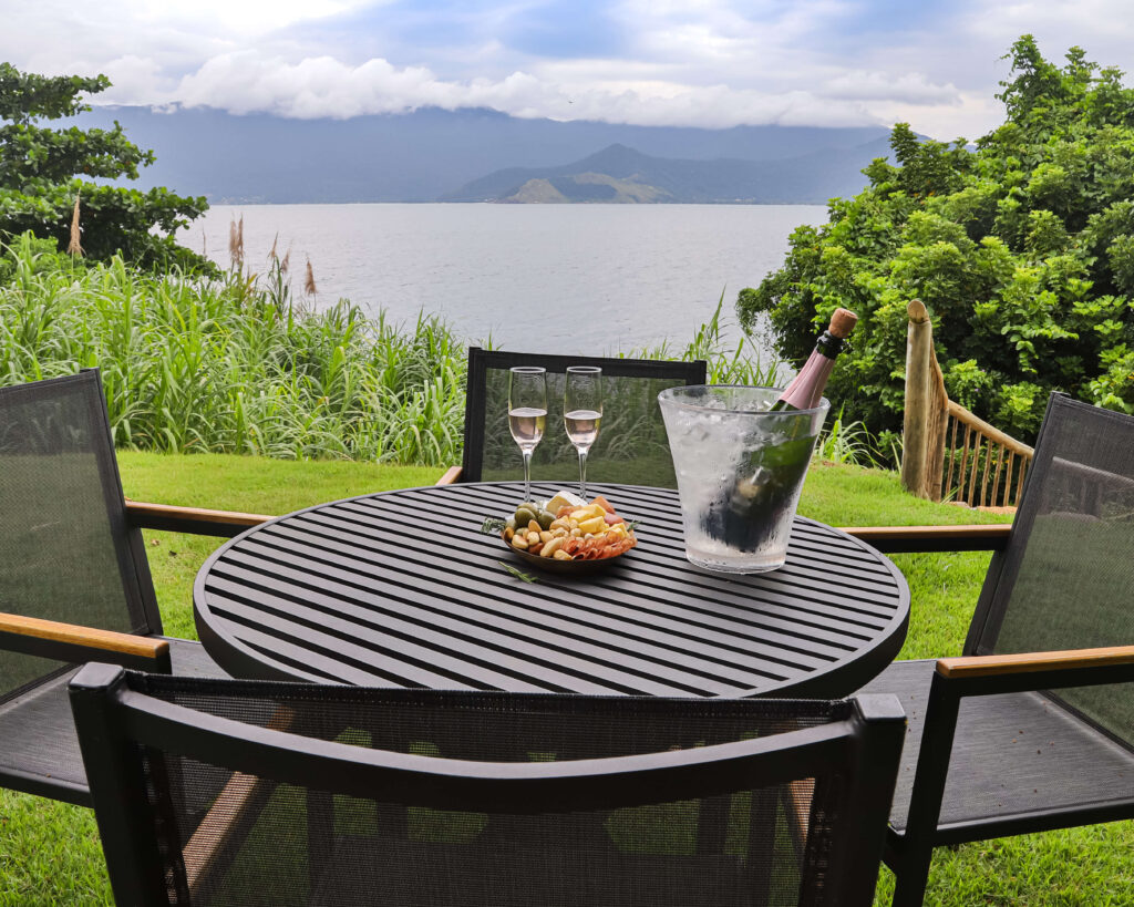 Vista de um lago com uma mesa a frente no hotel Casa di Sirena, em Ilhabela.