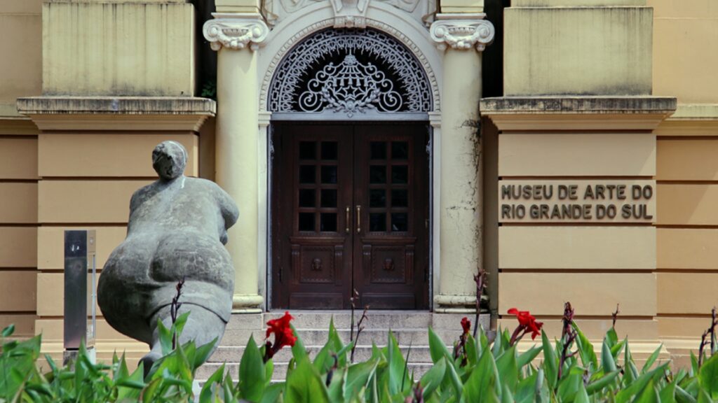 Fachada do Museu de Arte do Rio Grande do Sul. Há uma escultura cinza a esquerda da foto.