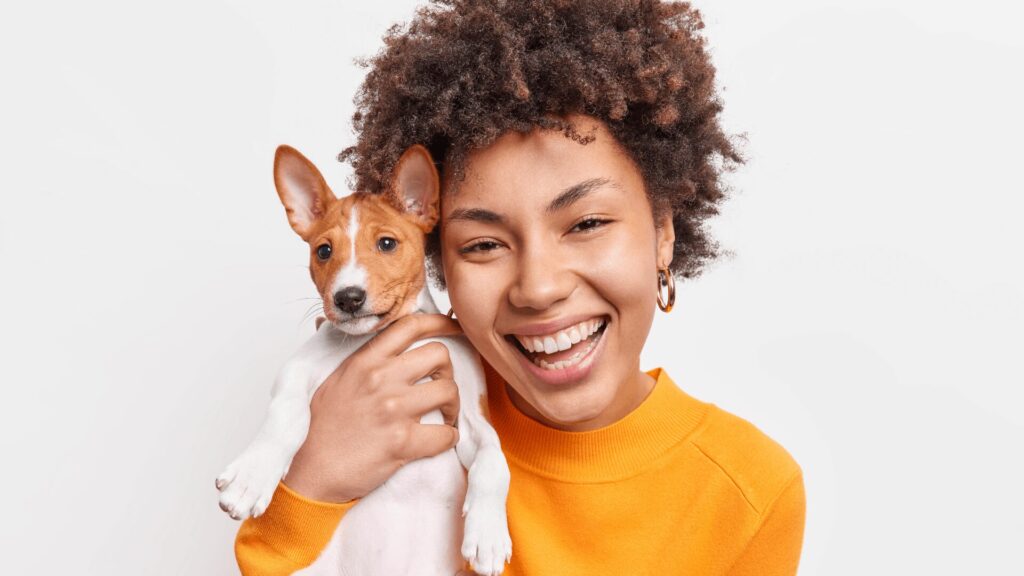 Imagem de uma mulher com um cachorro de porte pequeno.